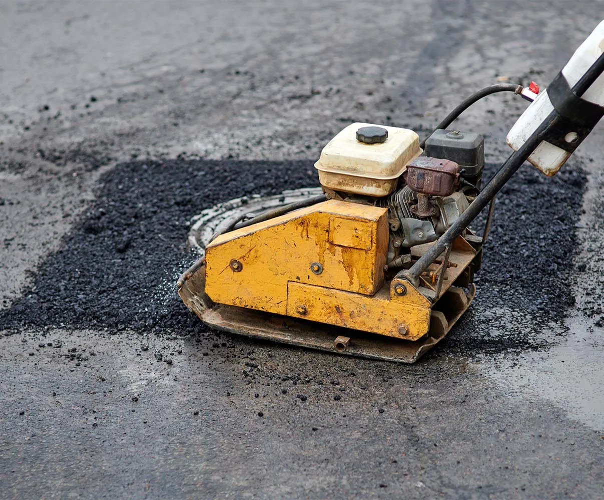 Pothole repair using asphalt paving equipment by a professional asphalt paving contractor.